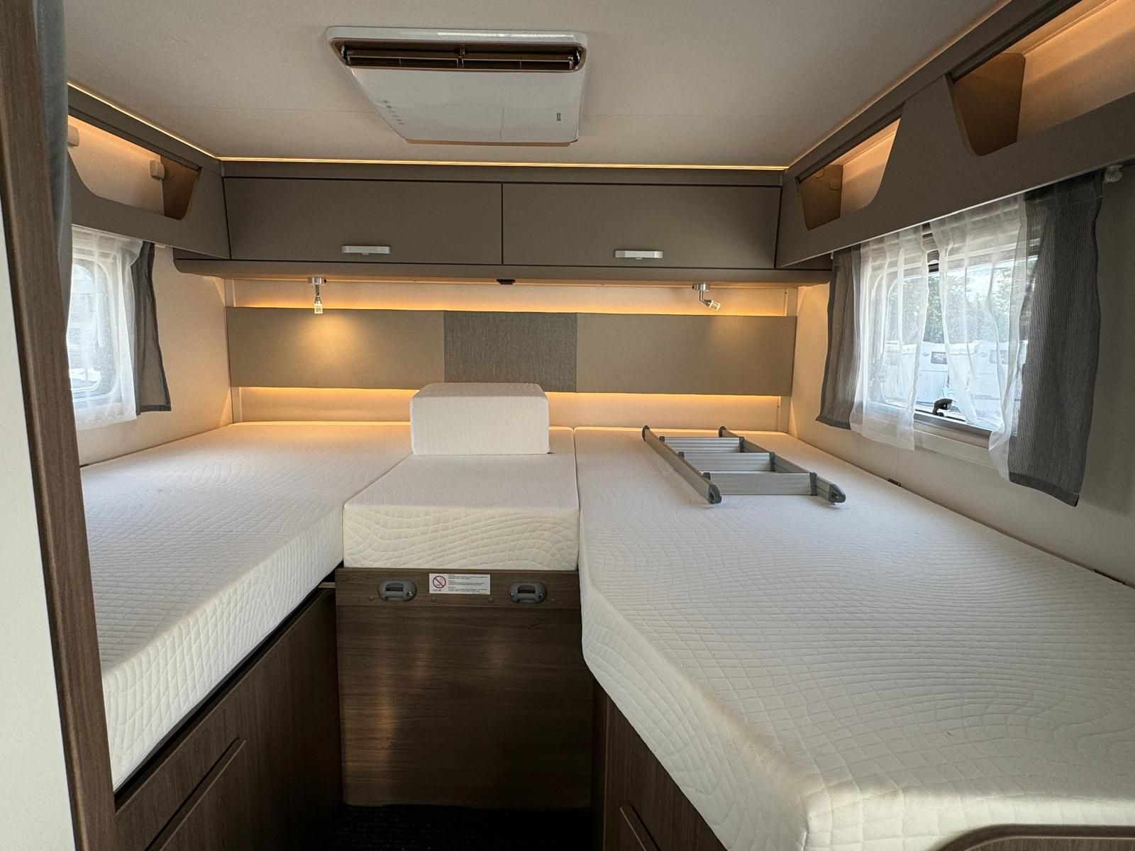 Das Innere eines Wohnmobils mit zwei Betten und einer Arbeitsplatte