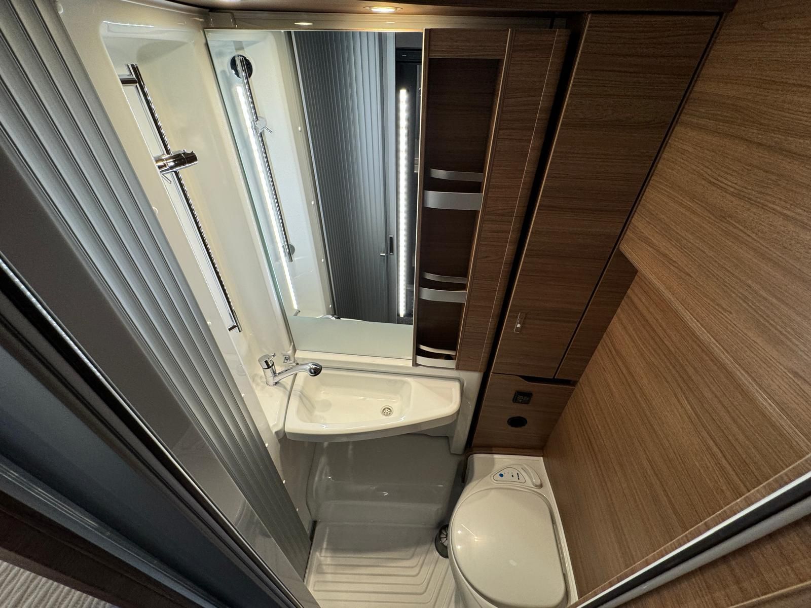 Ein Badezimmer mit Toilette, Waschbecken und Spiegel