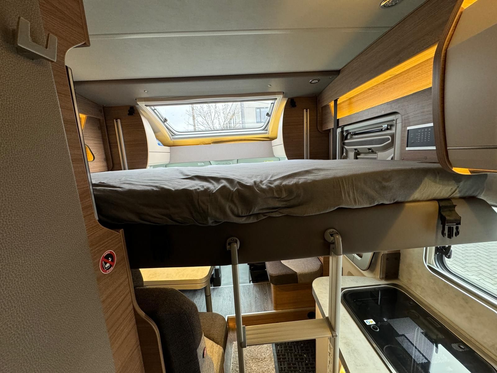 Ein Bett hängt von der Decke eines Wohnmobils.