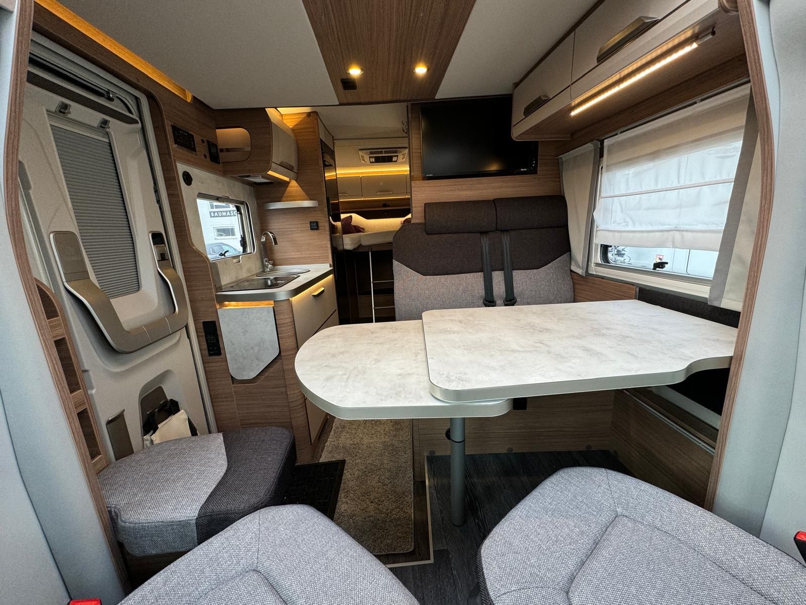 Das Innere eines Wohnmobils mit Tisch und Stühlen.