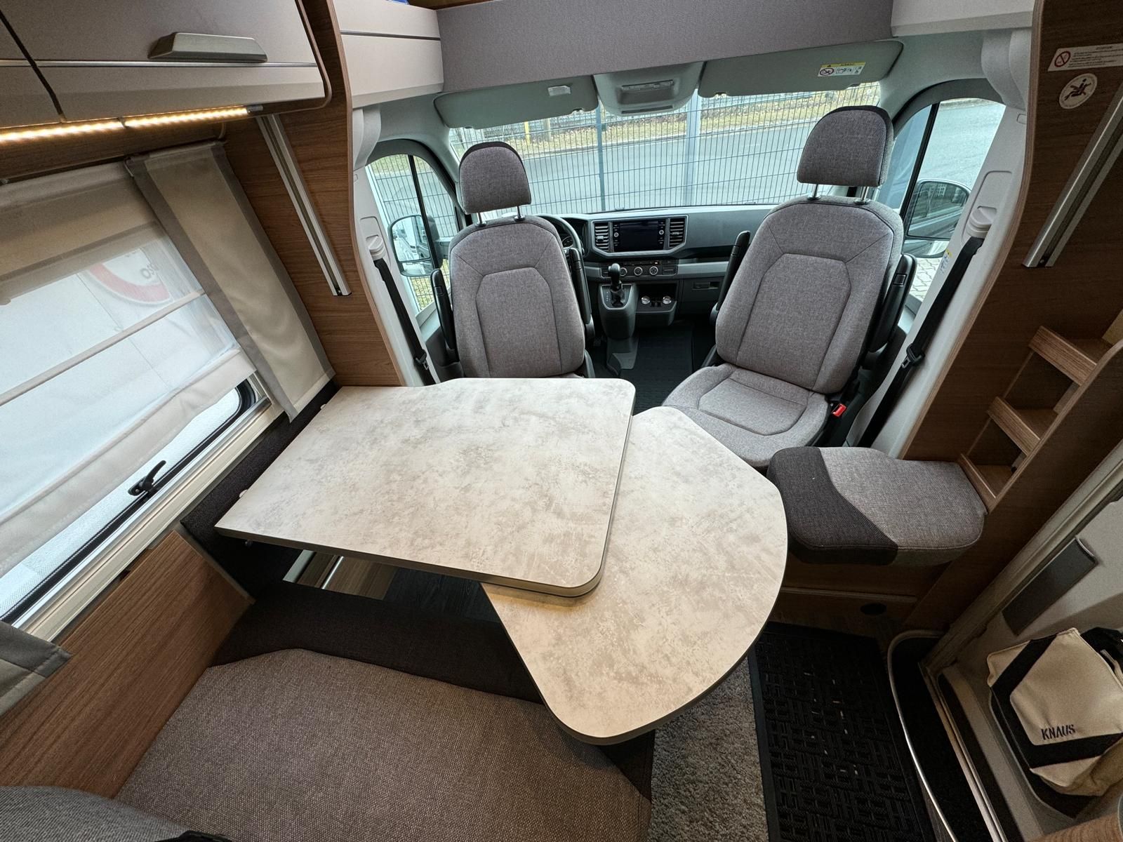 Das Innere eines Wohnmobils mit Tisch und Stühlen.