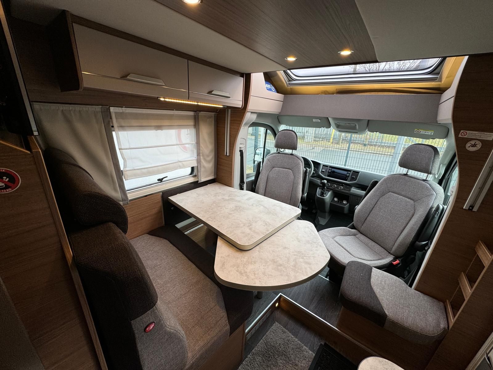 Das Innere eines Wohnmobils mit Tisch und Stühlen.