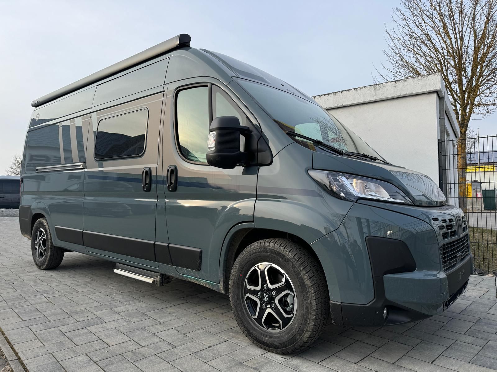 Ein weißer Lieferwagen steht vor einem Gebäude.