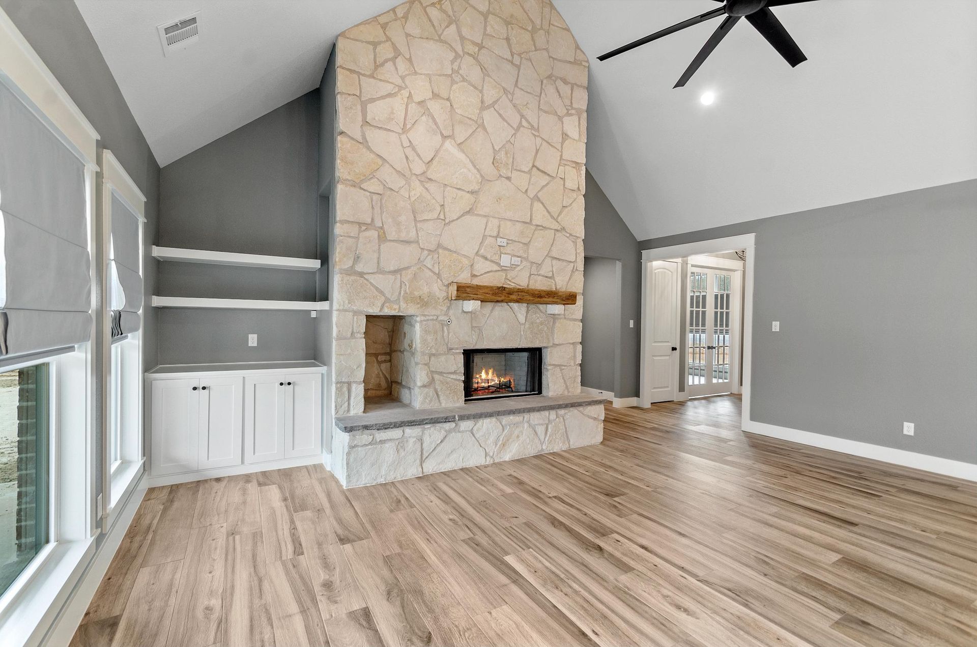 A living room with a fireplace and a ceiling fan.