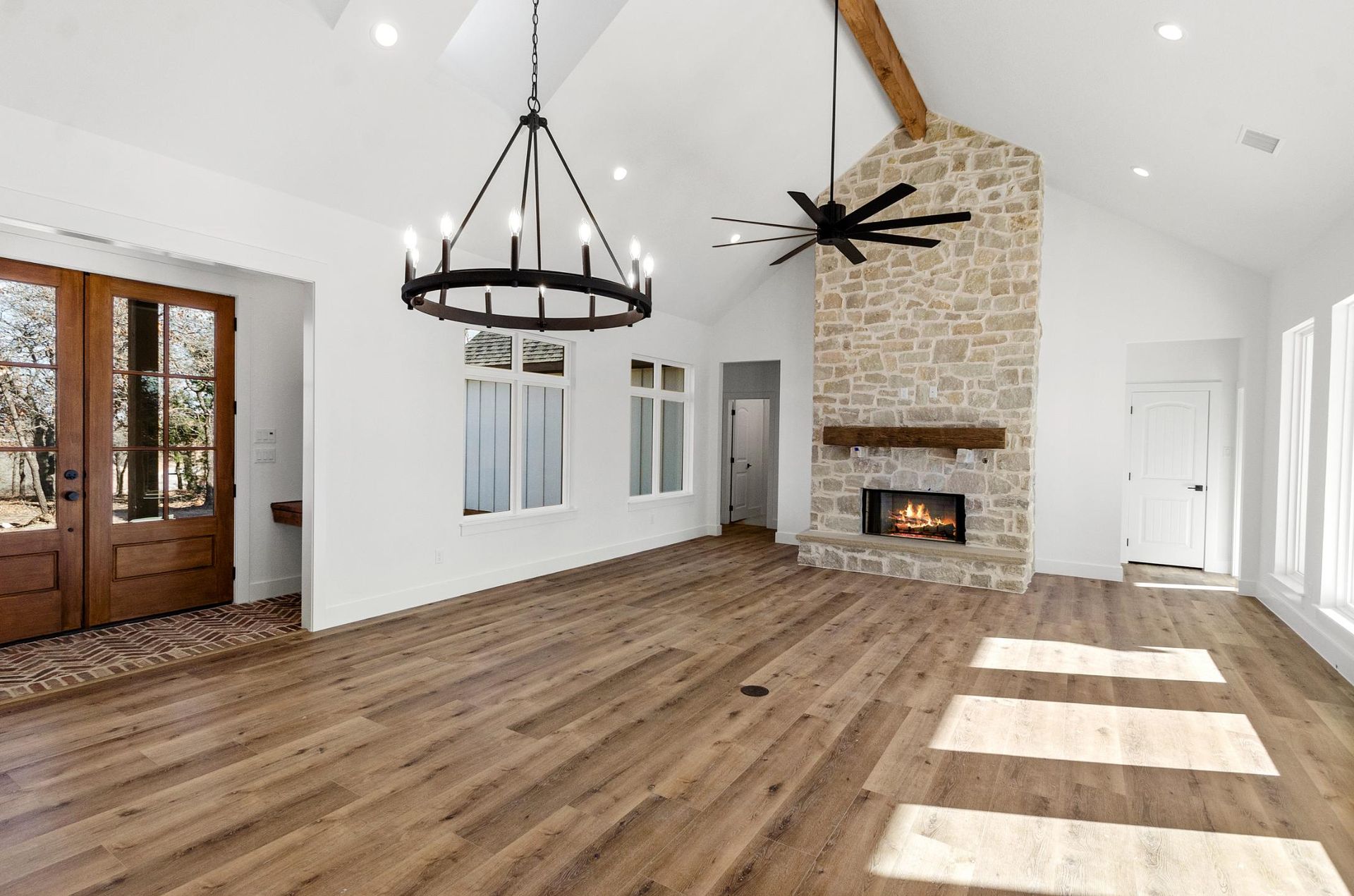A living room with hardwood floors, a fireplace, and a chandelier.