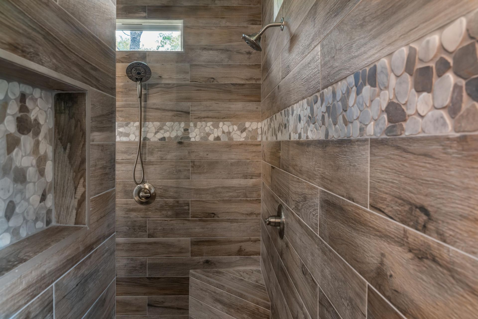 A shower with wooden tiles and rocks on the wall.