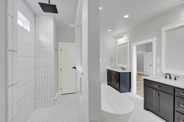 A bathroom with two sinks, a tub, and a shower.