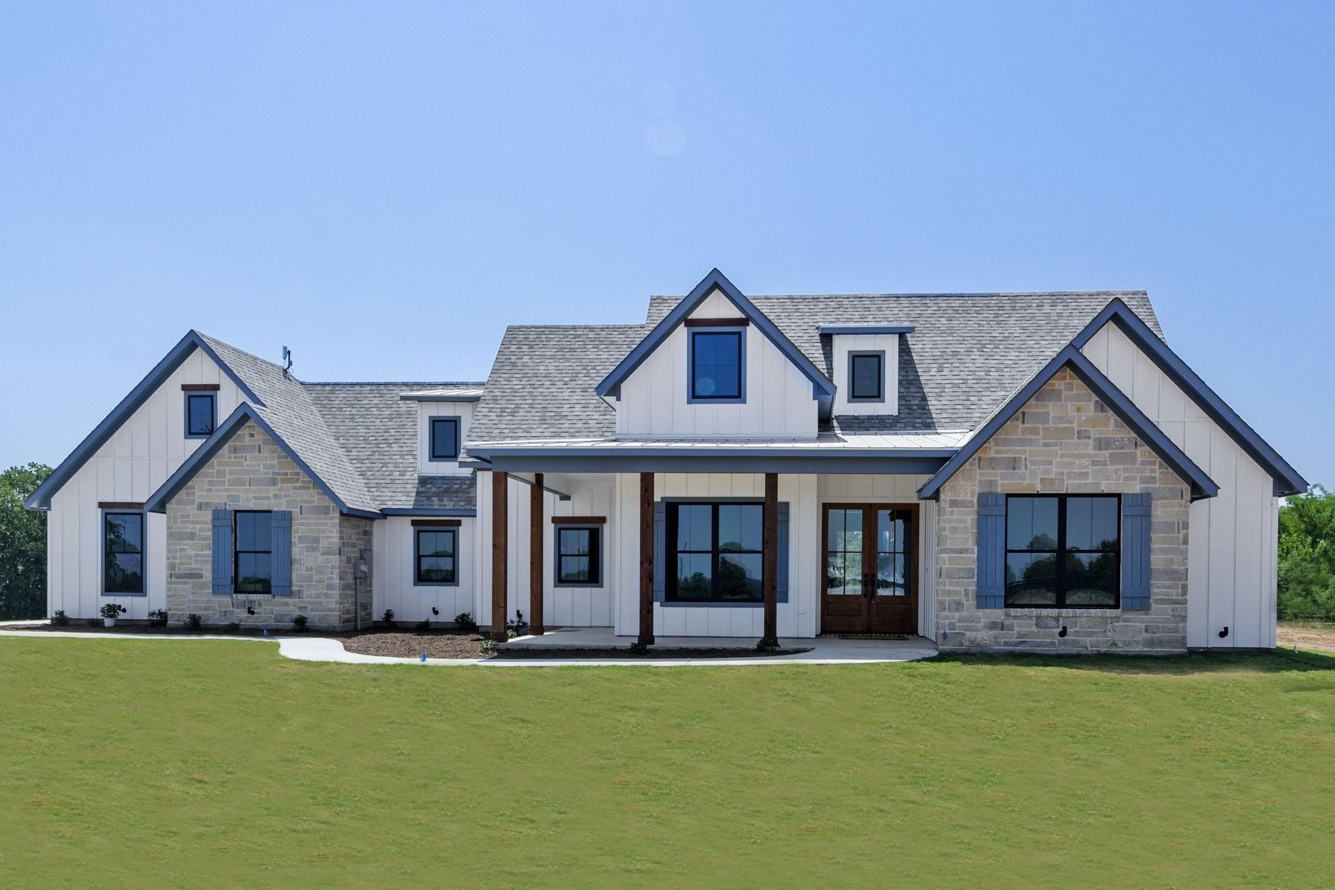 A large house with numerous windows stands in a vibrant green field.