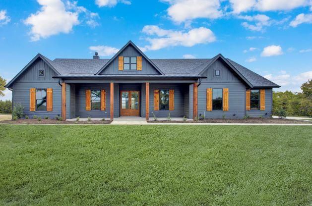 A large gray house with orange shutters.