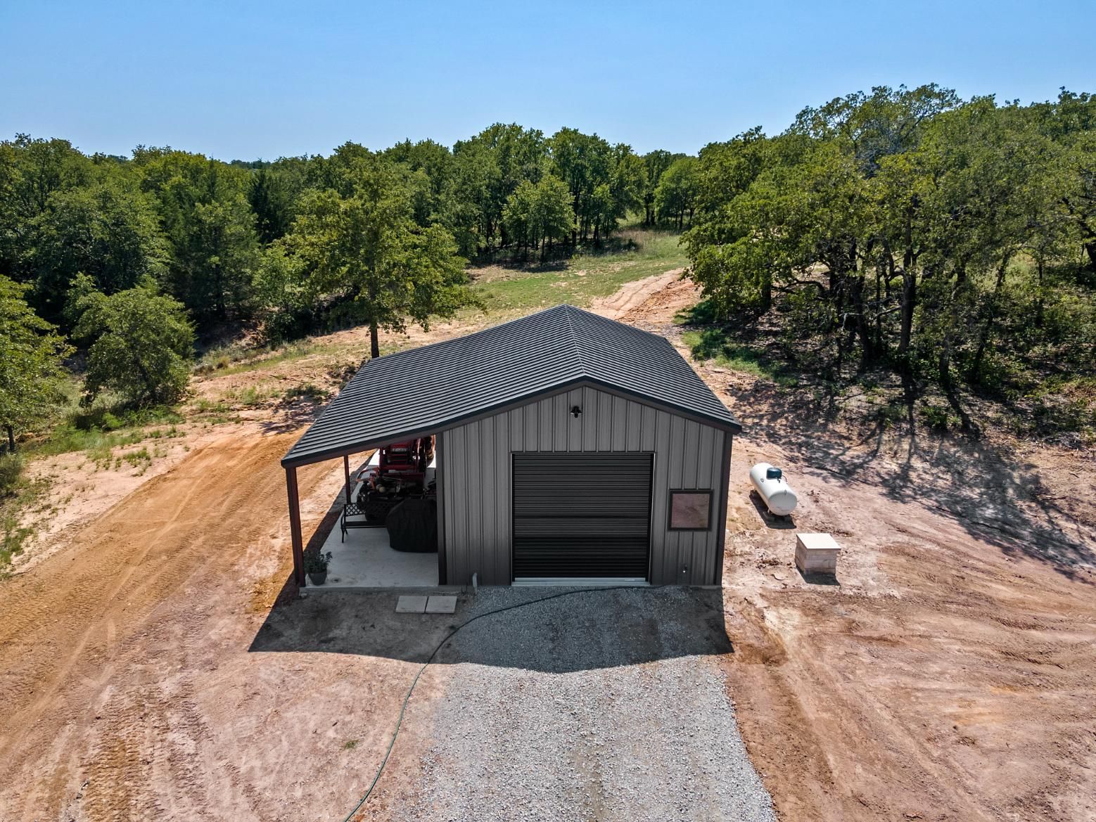 An aerial view of a garage surrounded by trees.