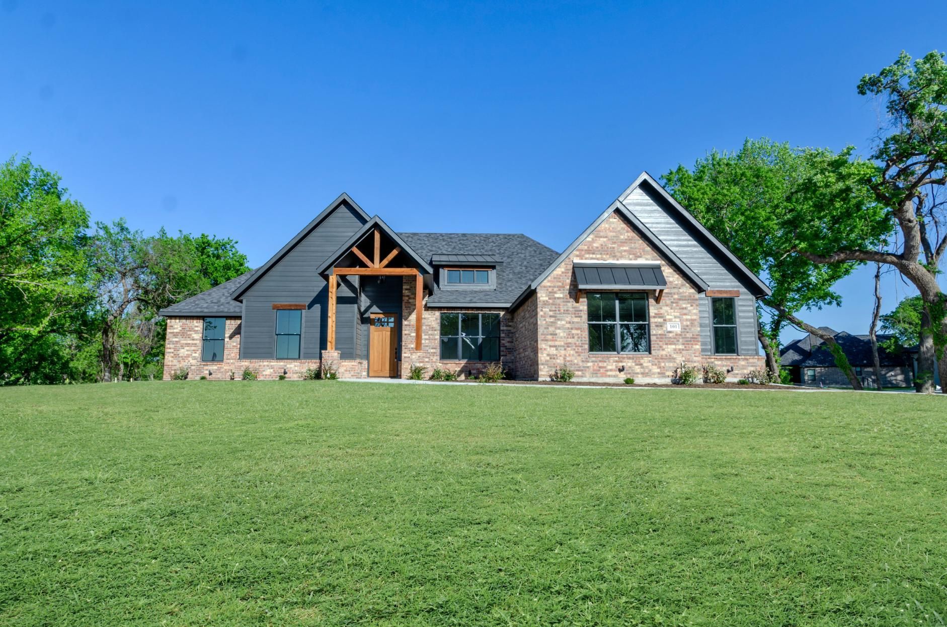 A large house is sitting on top of a lush green field.