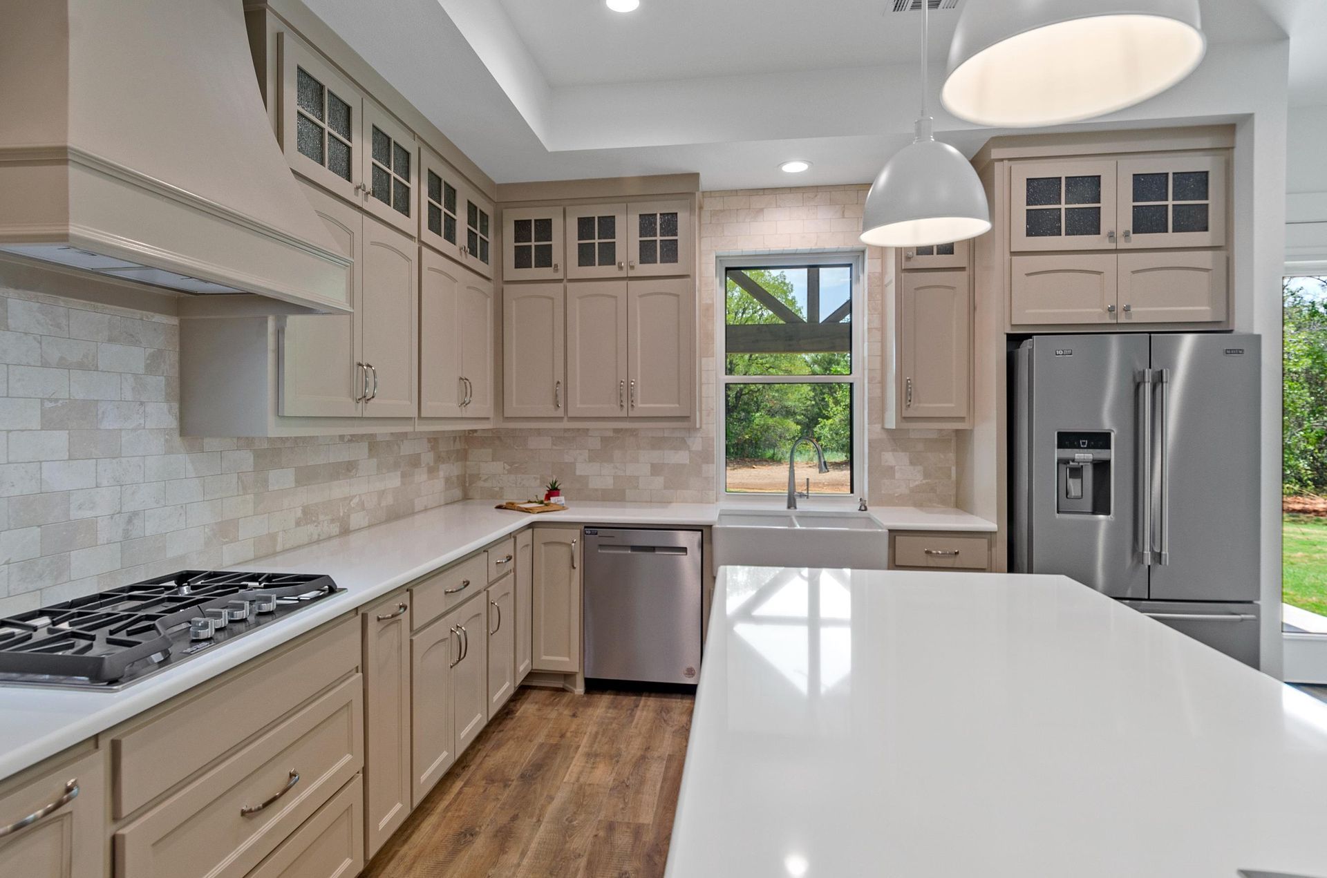 A kitchen with white cabinets, stainless steel appliances, and a large island.
