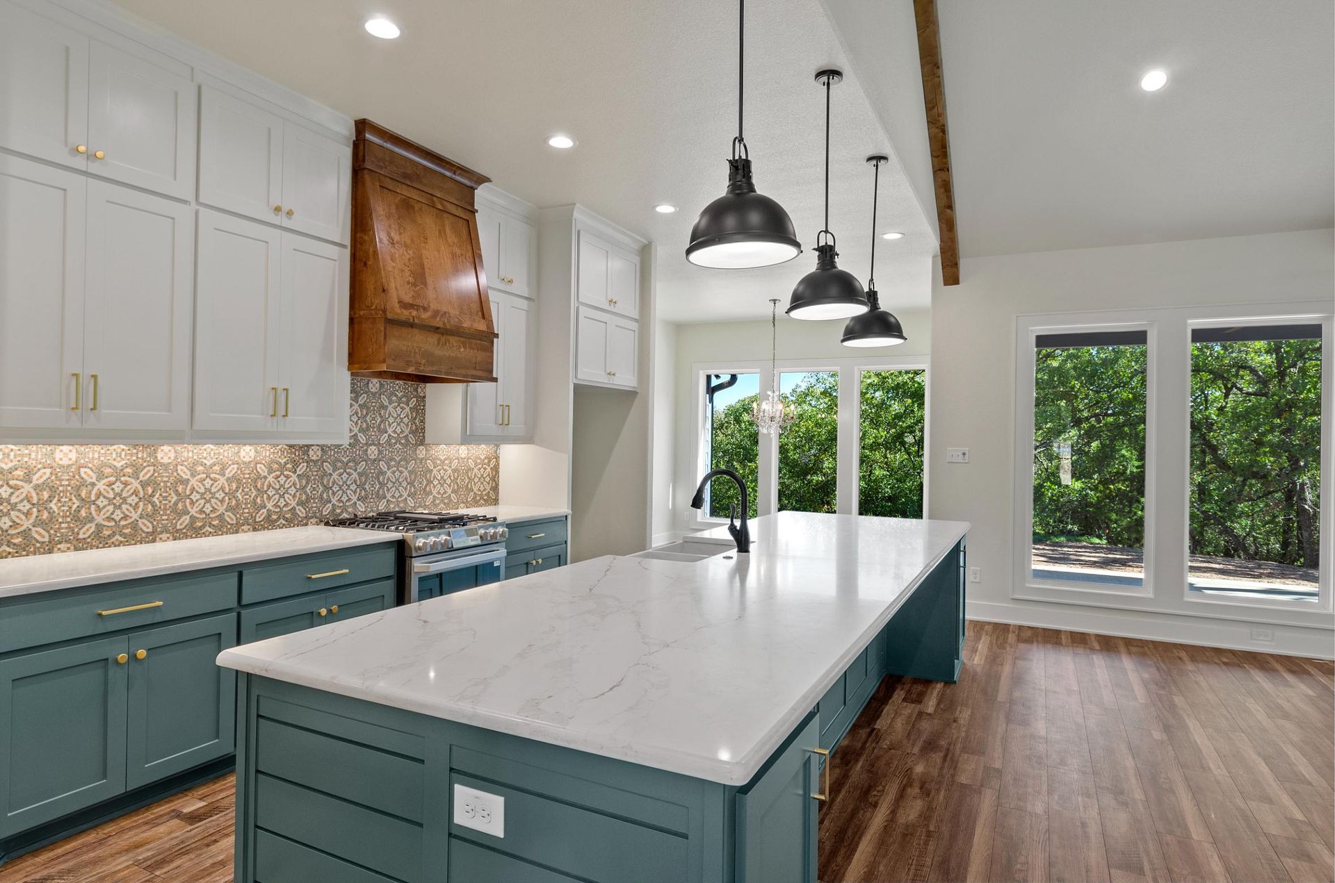 A kitchen with blue cabinets, white countertops, and a large island.