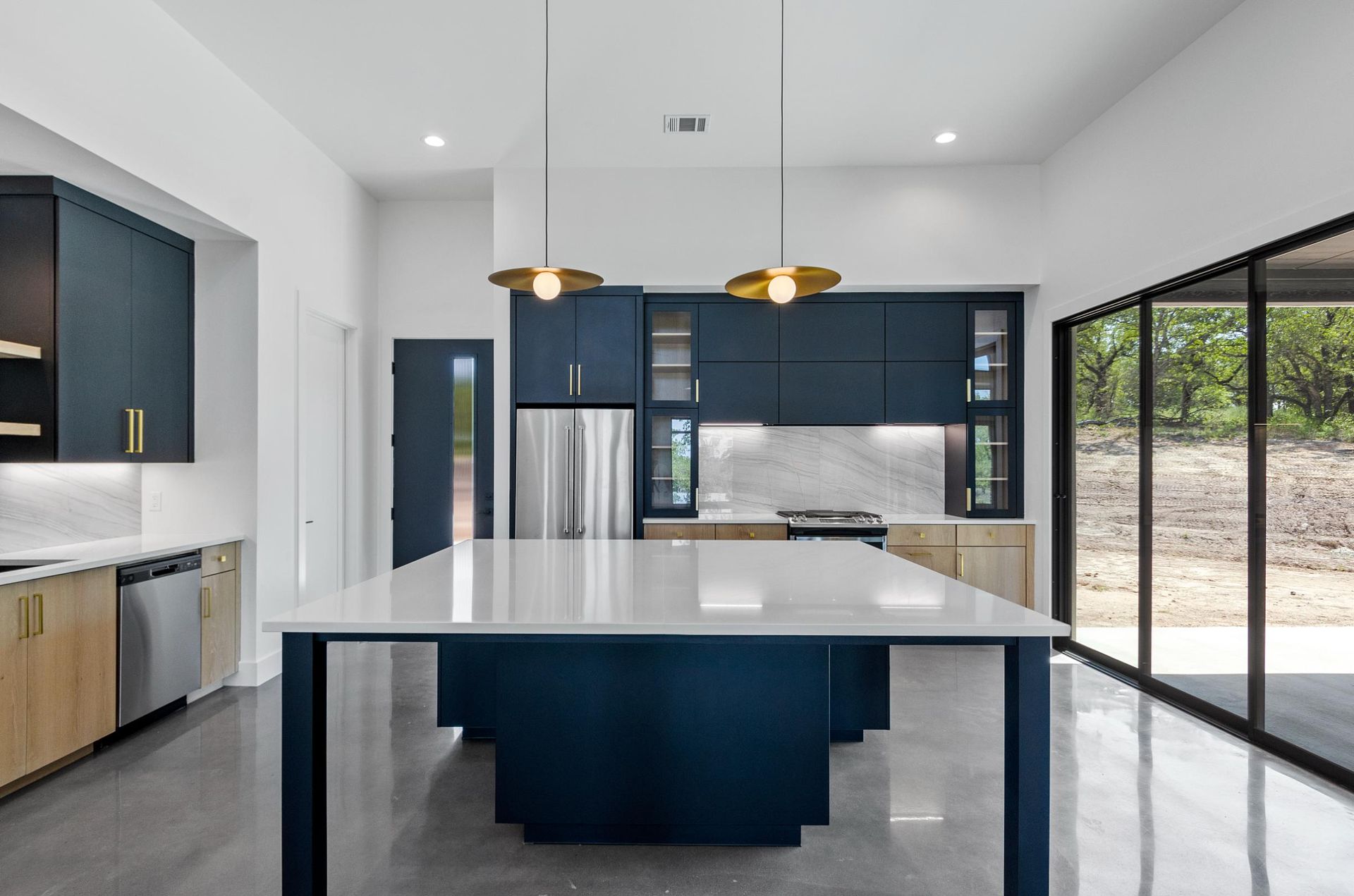 A kitchen with blue cabinets and a large island in the middle.
