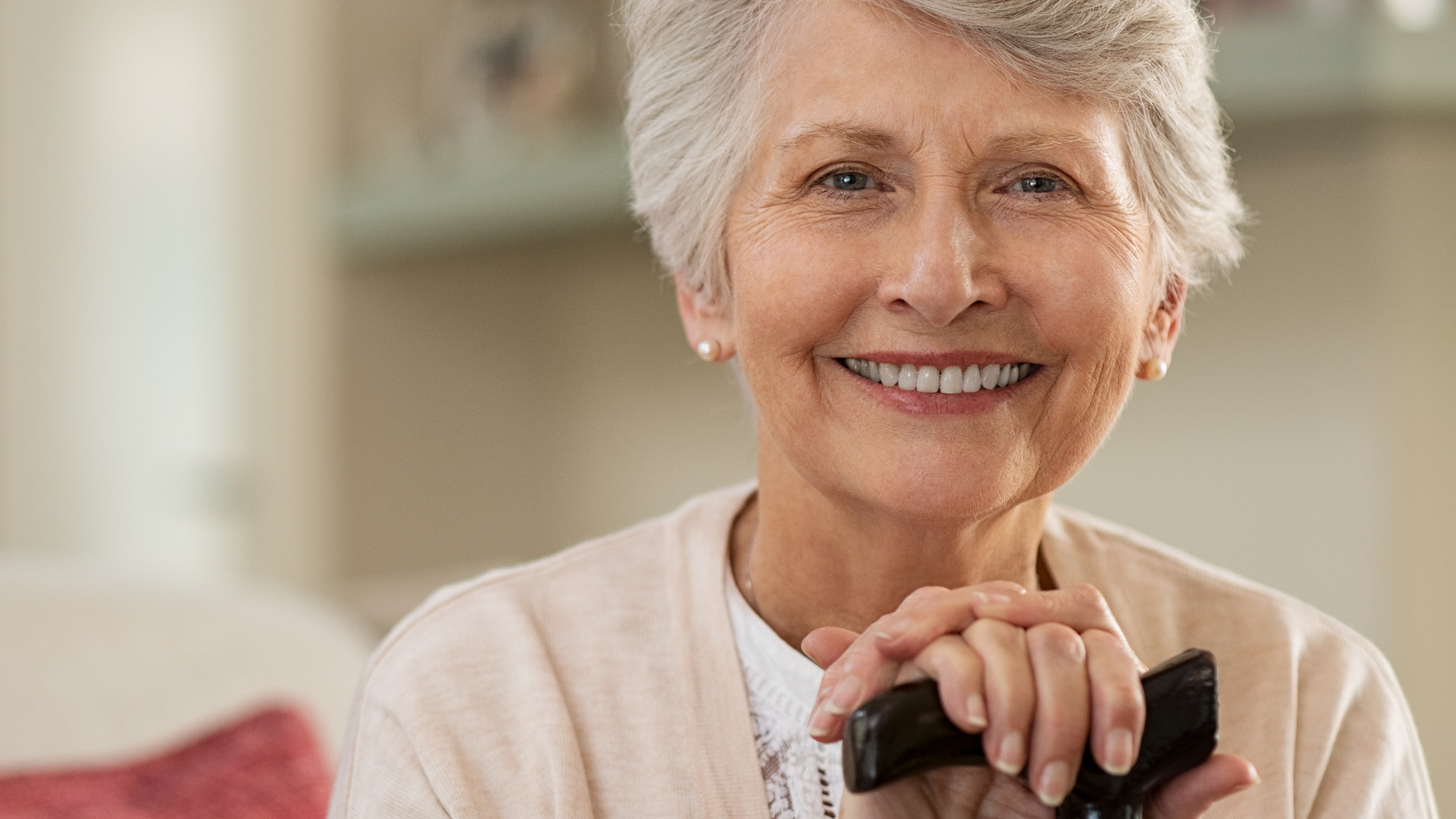 Smiling woman holding a remote control in a bright living room