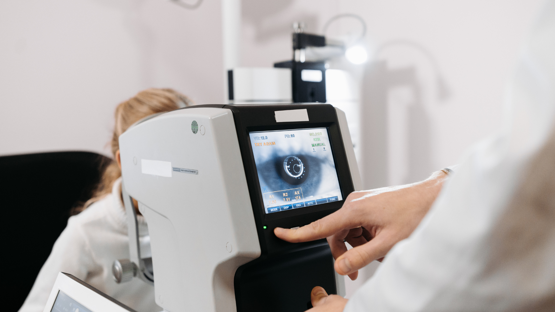 Person using a medical eye-scanning device with a touchscreen display in a clinic