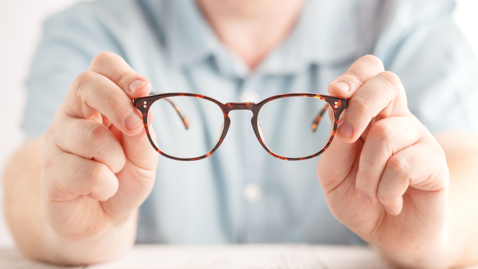 optometrist holding new glasses