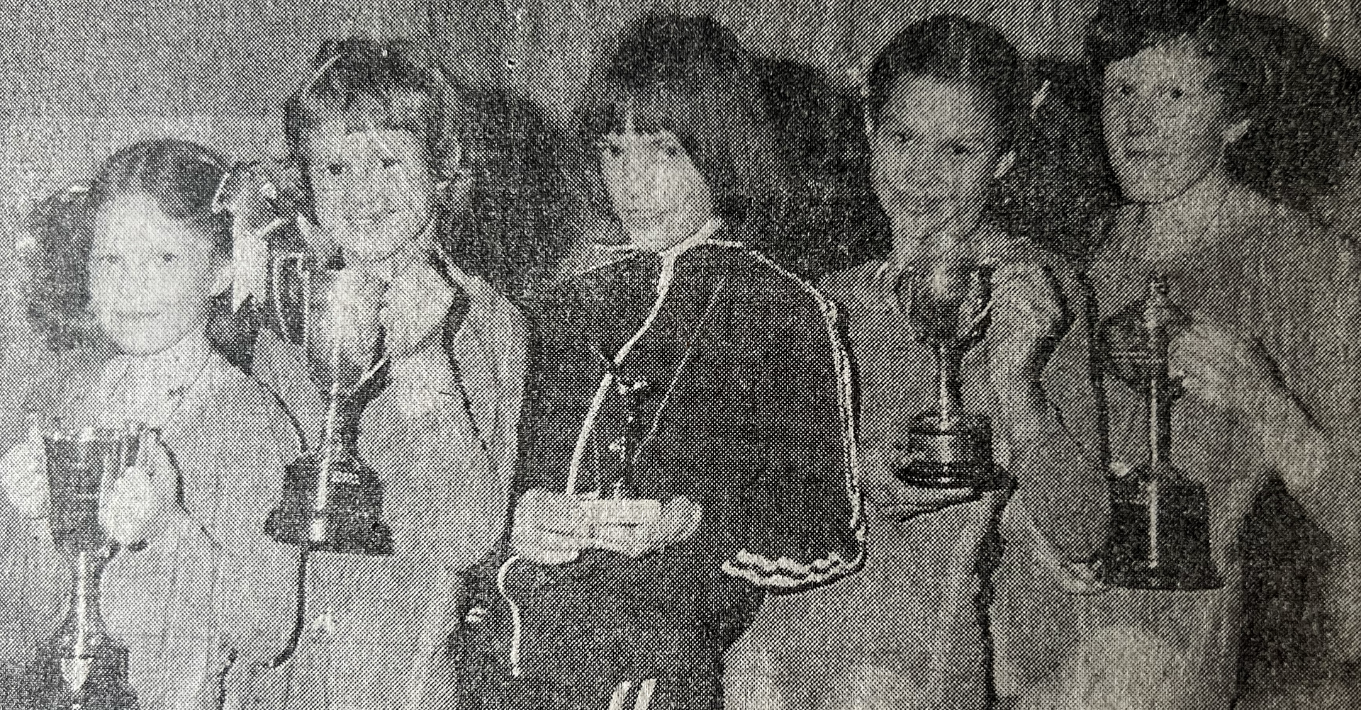 A group of women are standing next to each other in a black and white photo.