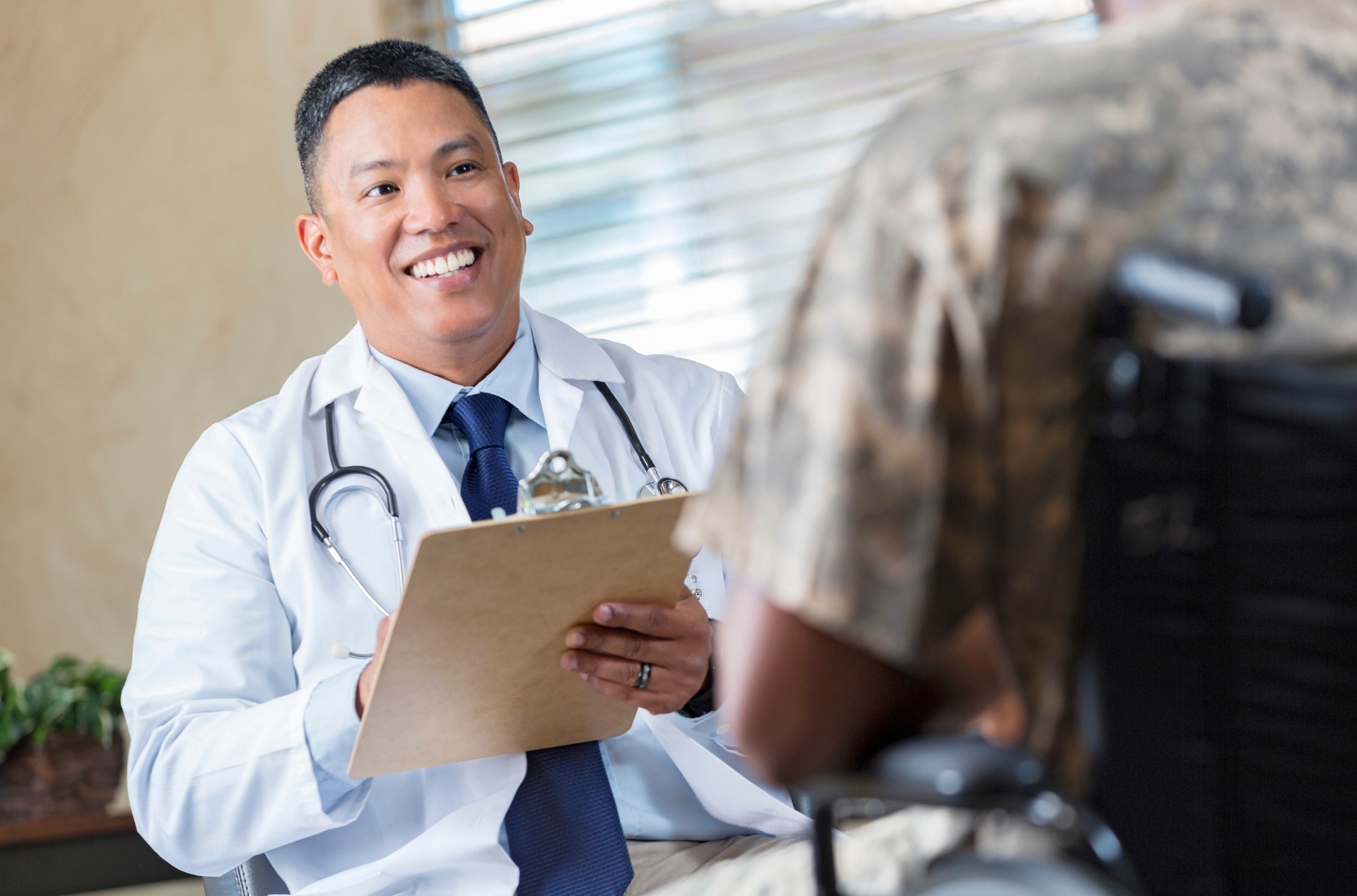 A woman is giving a man a massage on his neck.