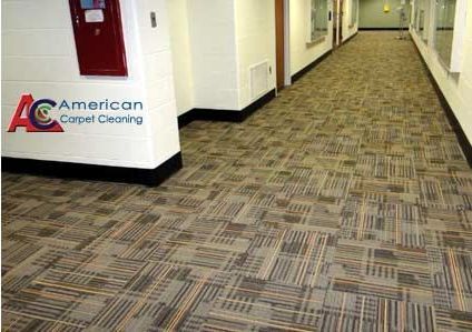 A long hallway with a carpeted floor and a sign that says american carpet cleaning.