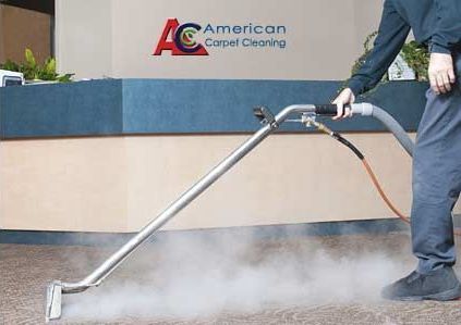 A man is using a vacuum cleaner in front of a sign that says american carpet cleaning