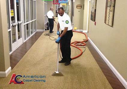 A man is cleaning a hallway with a vacuum cleaner.