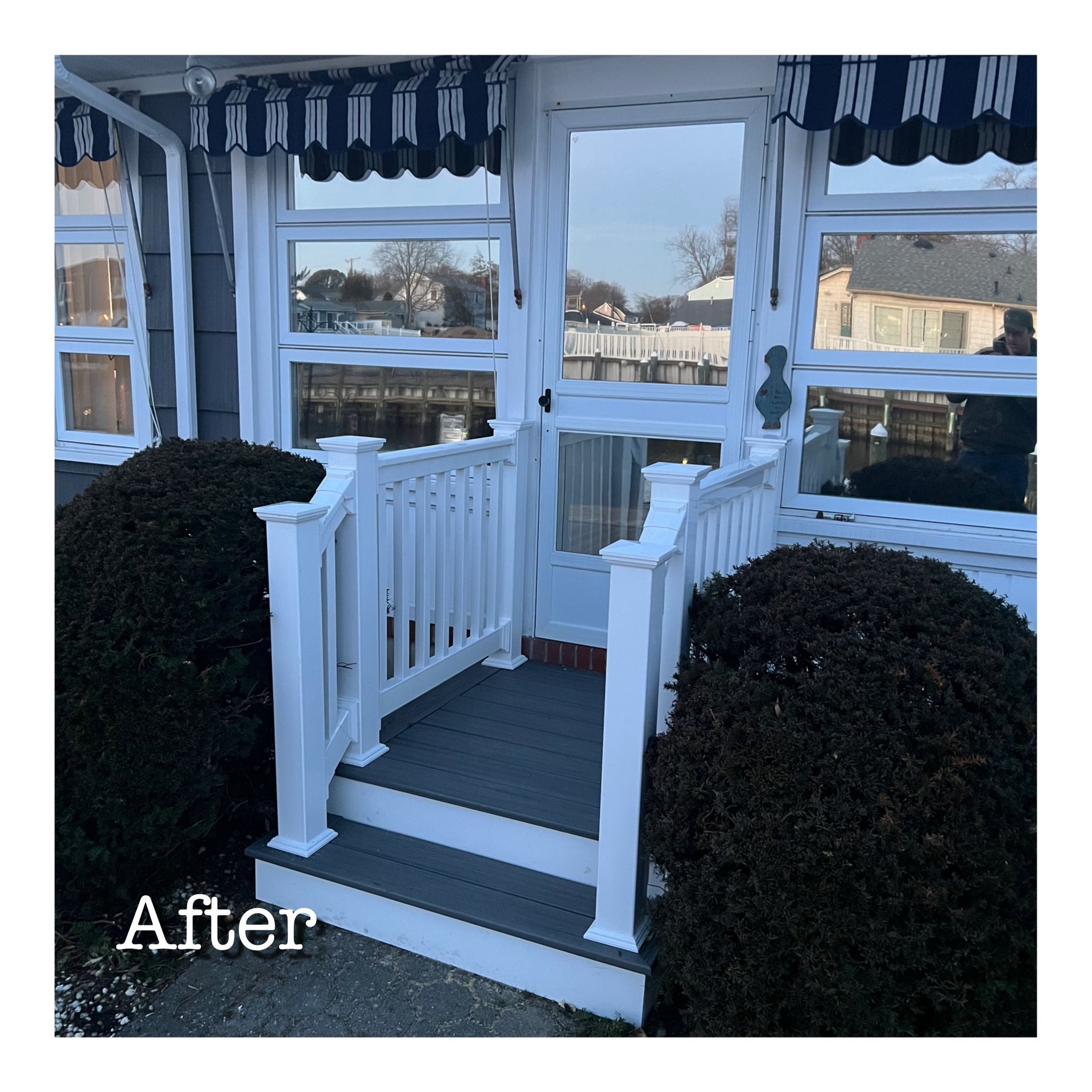 A picture of a house with a porch and stairs after being painted white.