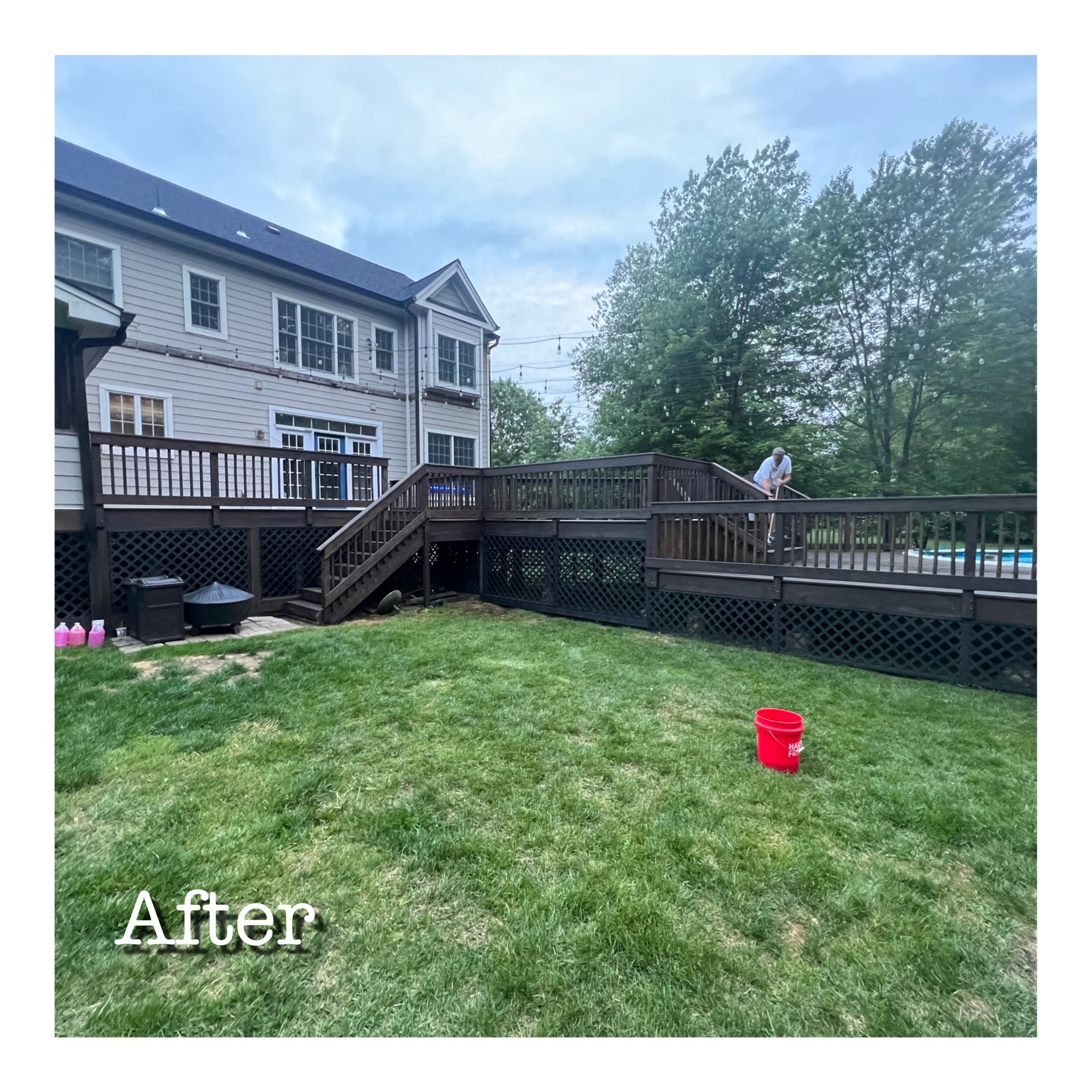 A house with a large deck and stairs in the backyard.