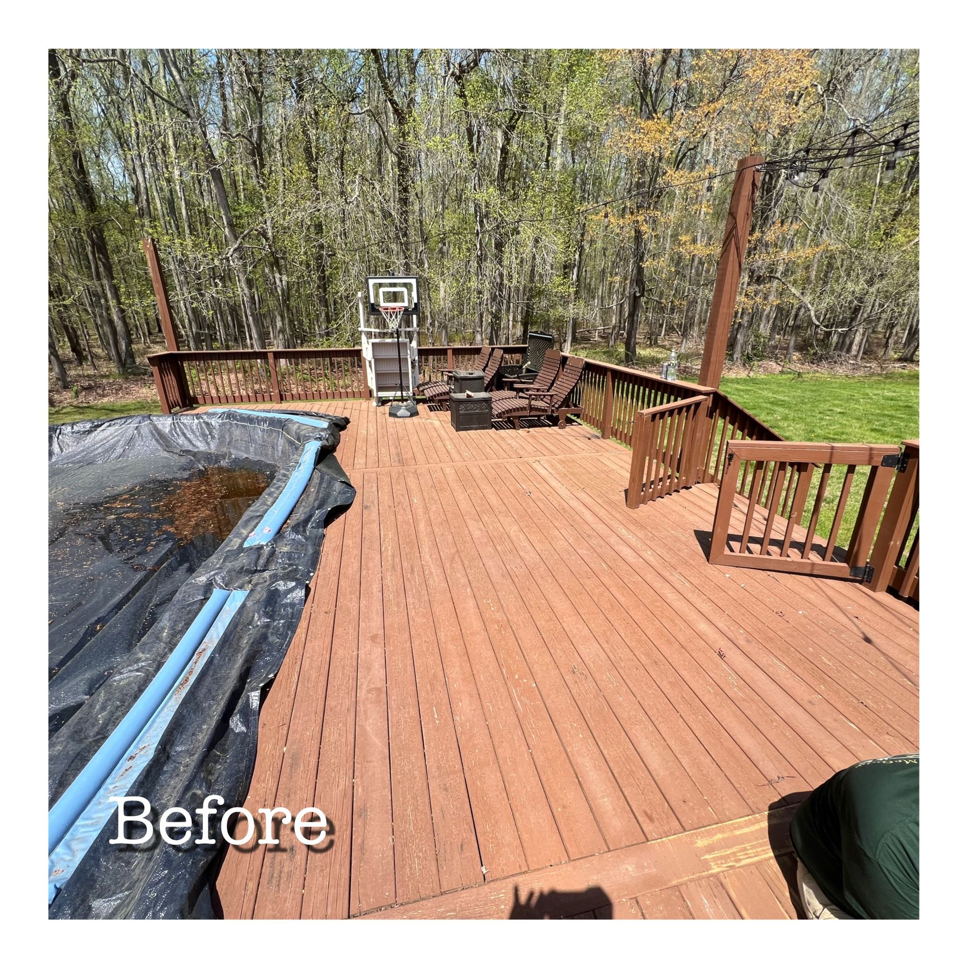 A before picture of a wooden deck with a basketball hoop and chairs.