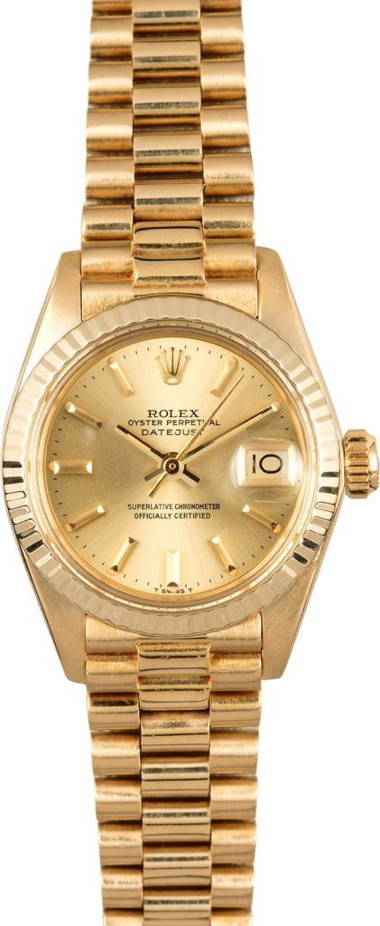 Gold Rolex wristwatch with a champagne dial and date display on a gold bracelet.
