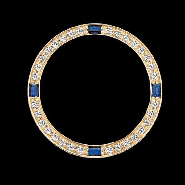Gold ring with alternating blue and clear stones on a black background
