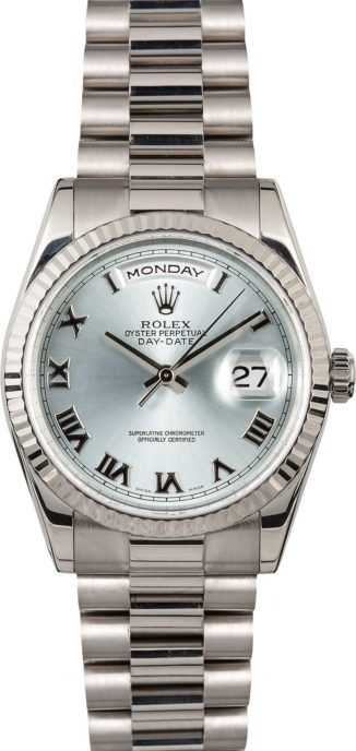 Silver Rolex watch with white dial and Roman numerals, showing Monday and date 27