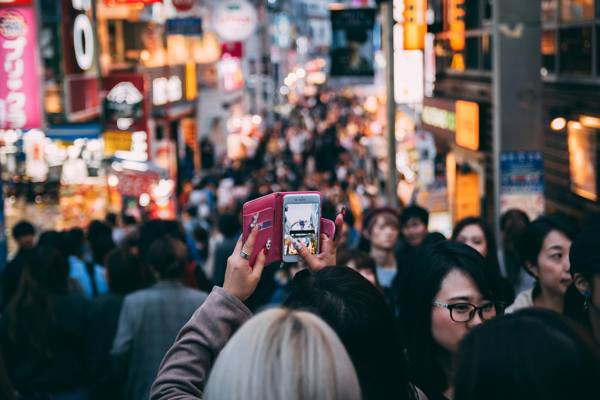 A woman is taking a picture of a crowd of people.