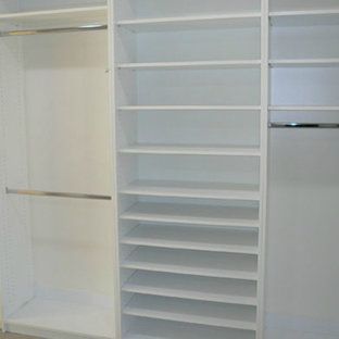 A walk in closet with lots of shelves and clothes racks.