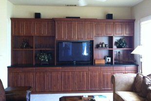 A living room with wooden cabinets and a flat screen tv