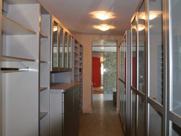 A long hallway with lots of shelves and glass doors