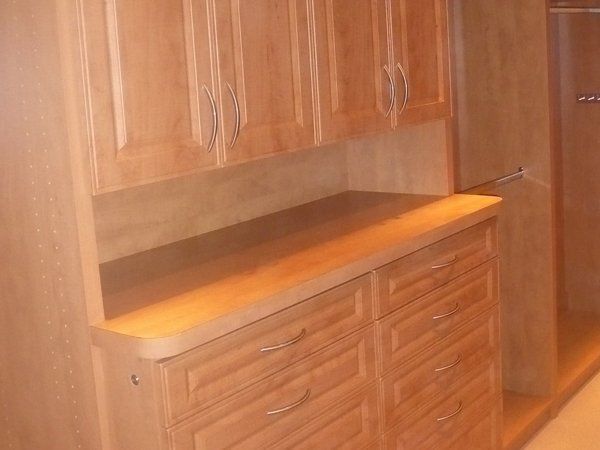 A wooden cabinet with drawers and cabinet doors in a kitchen.
