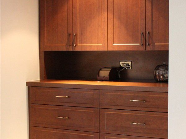 A kitchen with wooden cabinets and drawers and a toaster oven