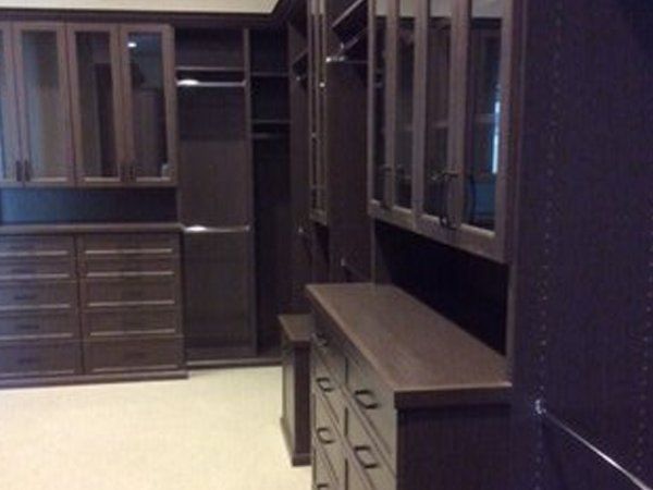 A walk in closet with lots of cabinets and drawers