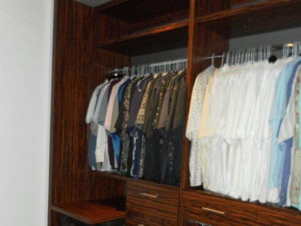 A walk in closet filled with clothes and drawers