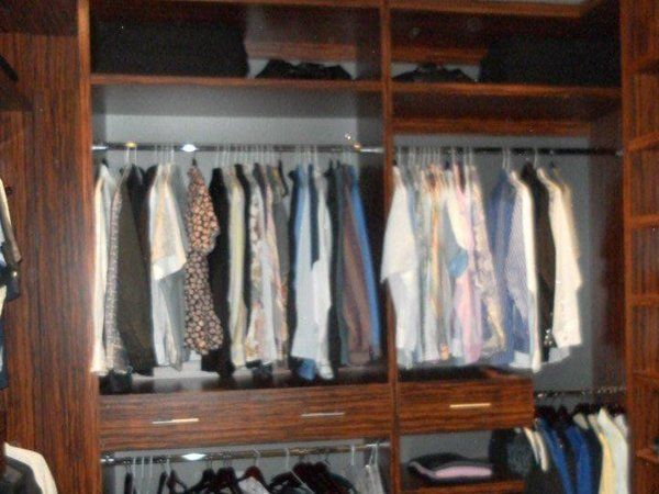 A walk in closet filled with lots of clothes