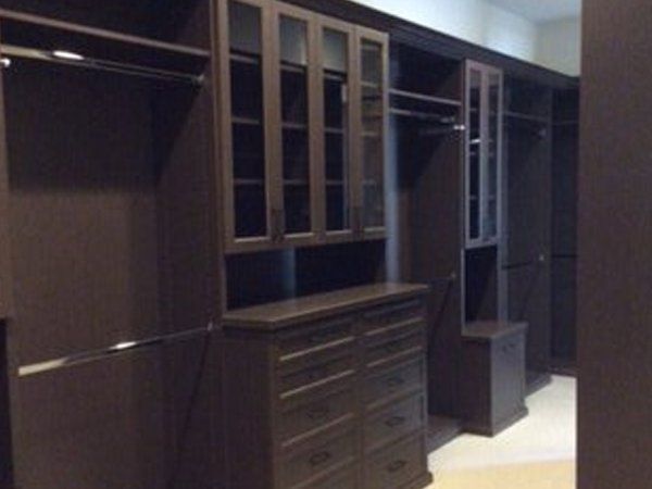 A walk in closet with lots of cabinets and drawers