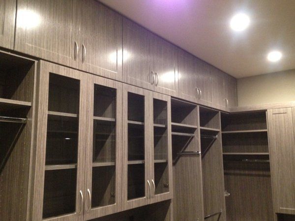 A walk in closet with lots of cabinets and shelves