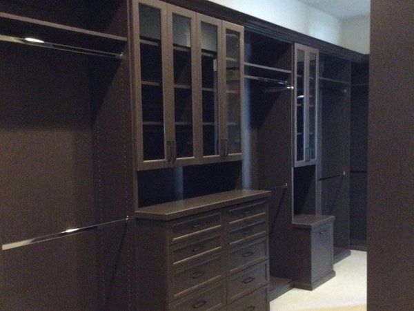 A walk in closet with lots of cabinets and drawers