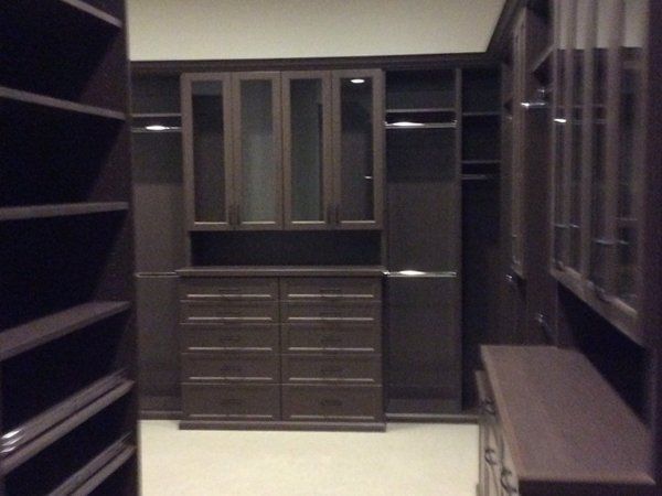 A walk in closet with lots of drawers and shelves