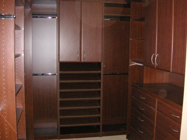 A walk in closet with lots of shelves and drawers