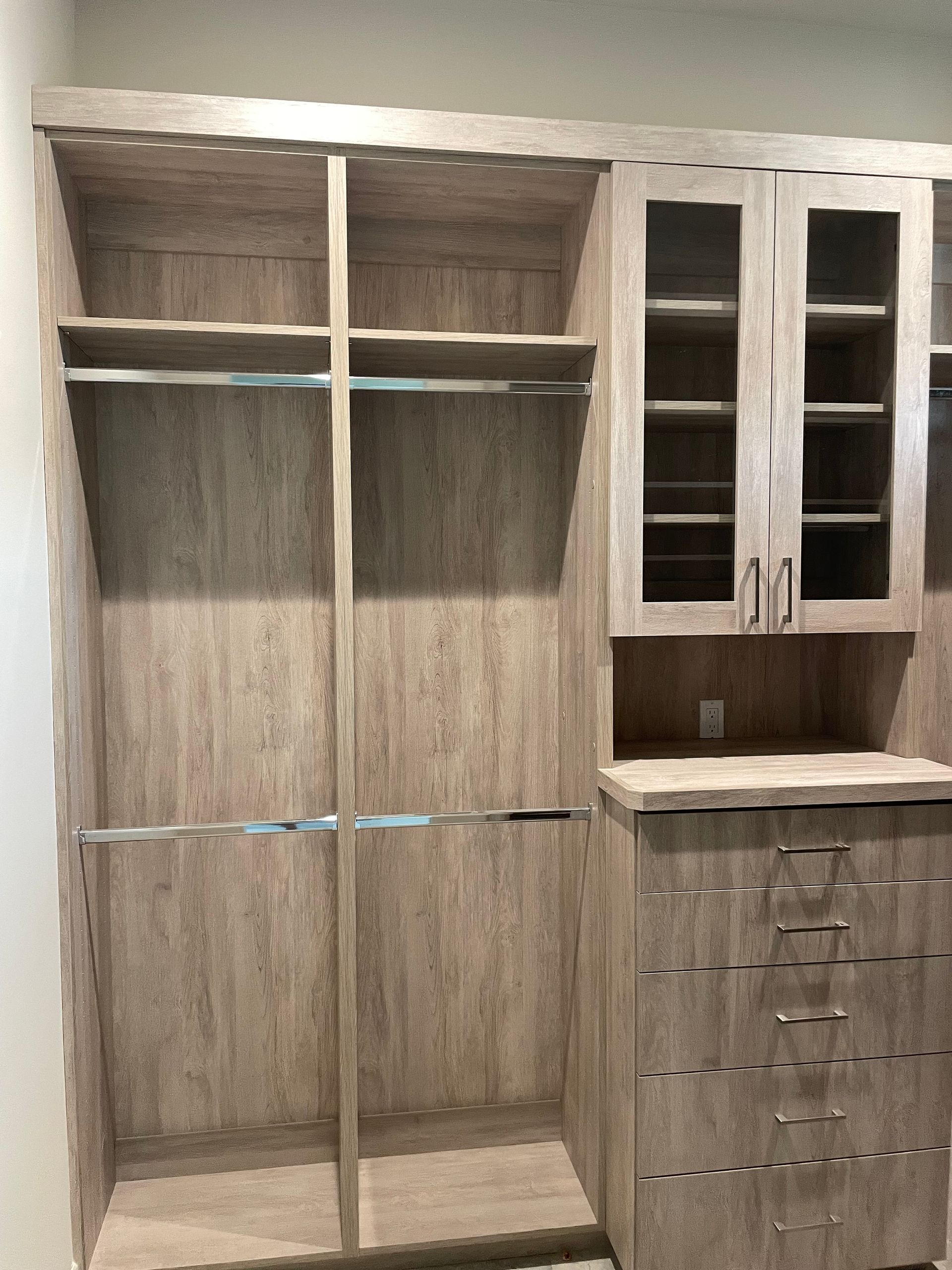 A walk in closet with lots of shelves and drawers.