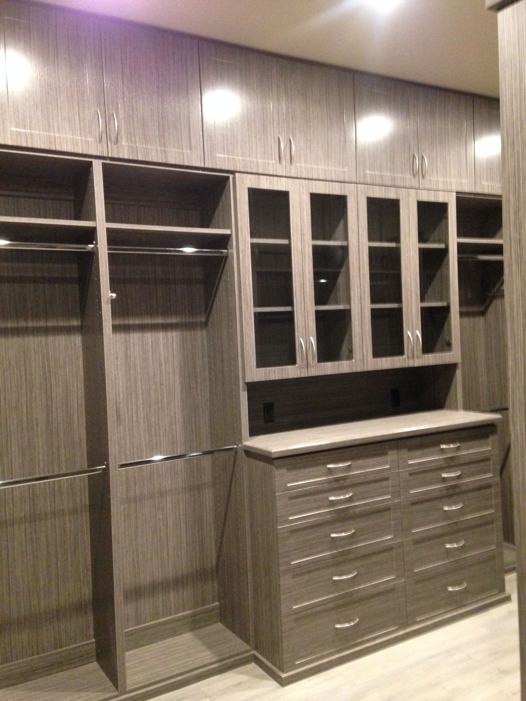 A walk in closet with lots of shelves and drawers.