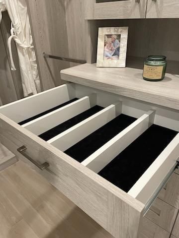 A drawer with black dividers and a picture on top of it.