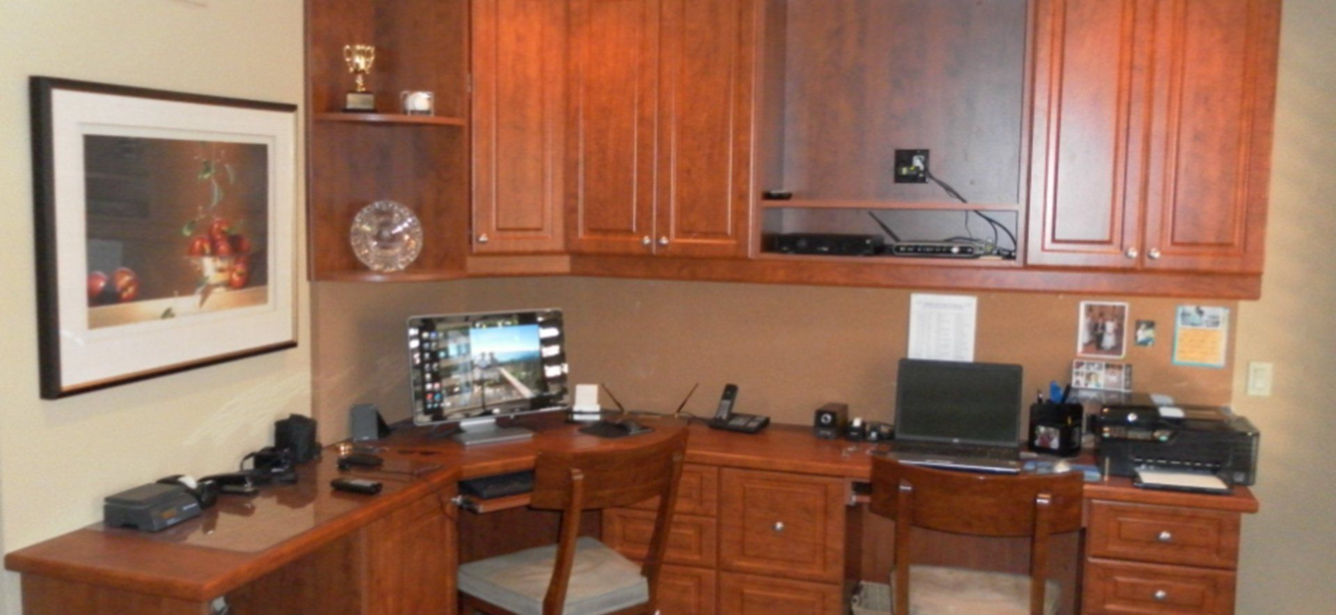 A home office with wooden cabinets and a computer desk